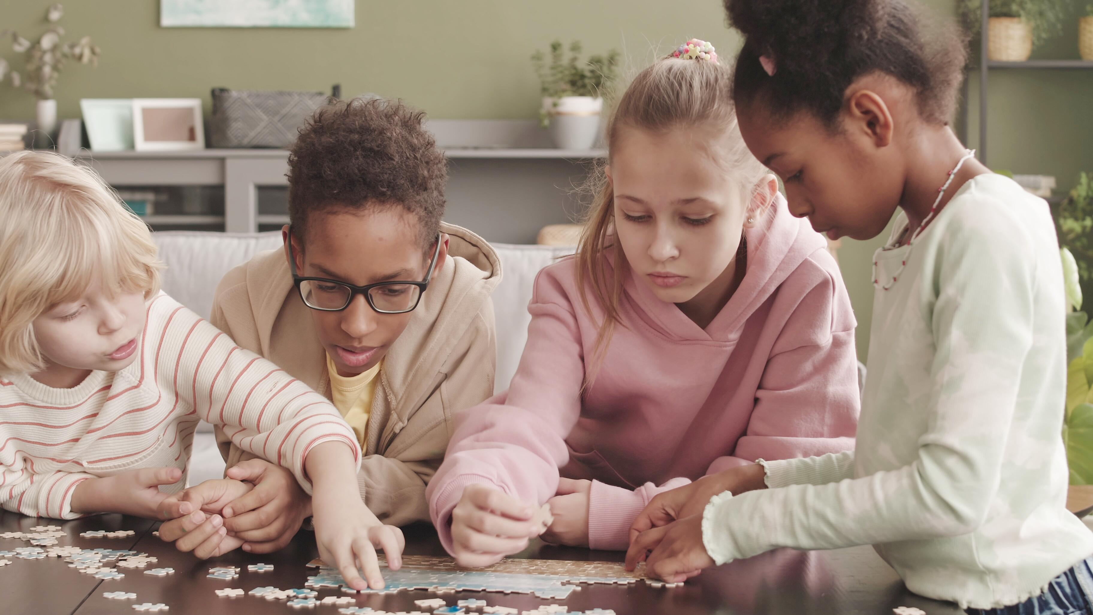 Two siblings collaborating to complete a puzzle at home