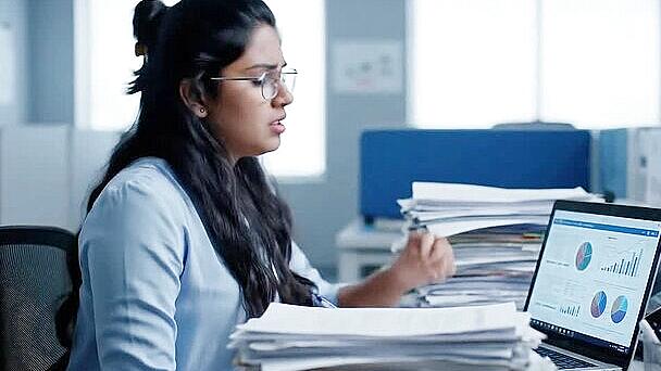 person at desk showing signs of feeling overwhelmed at work