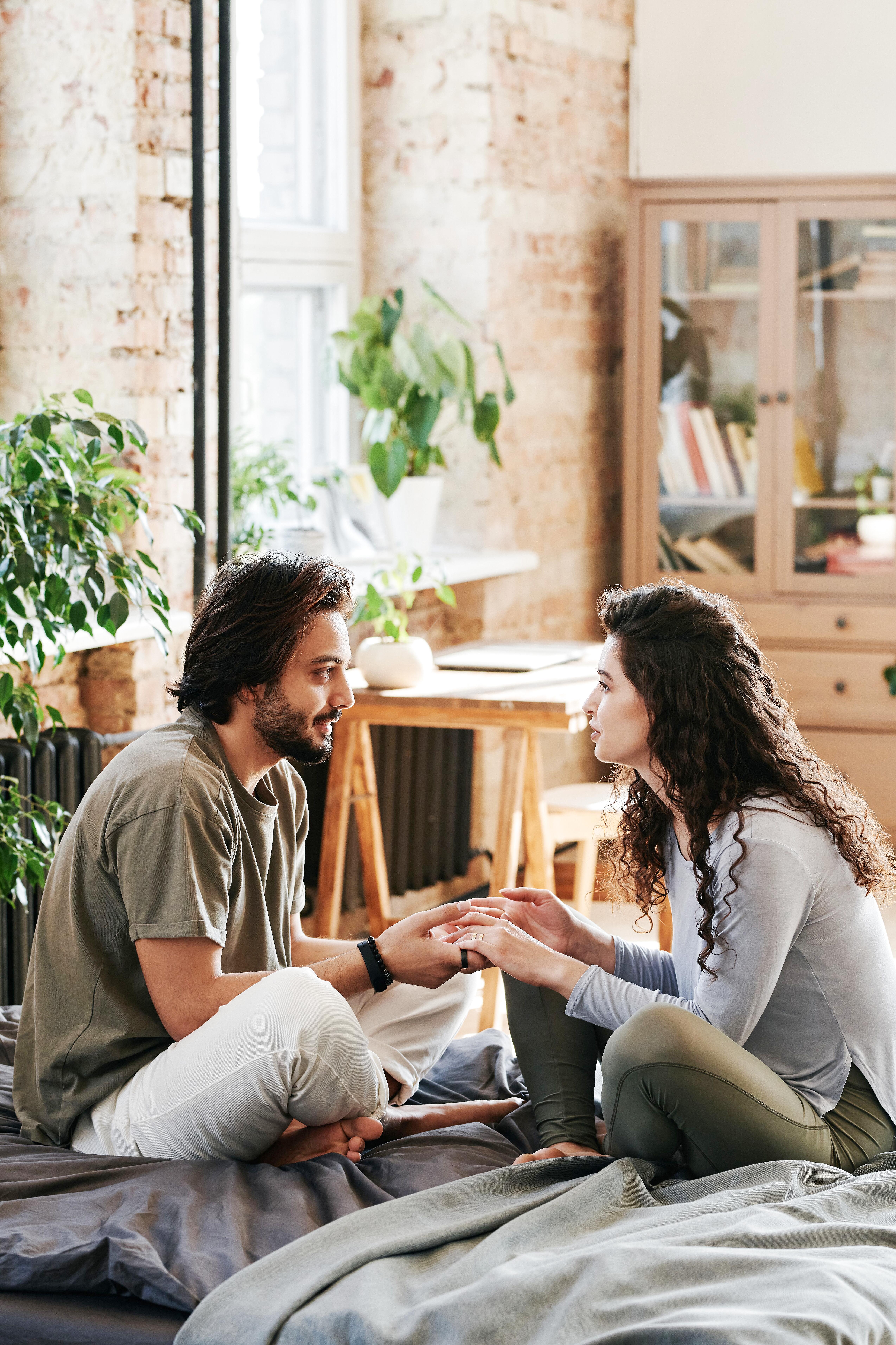 Couple engaged in deep emotional conversation on couch showing intimacy