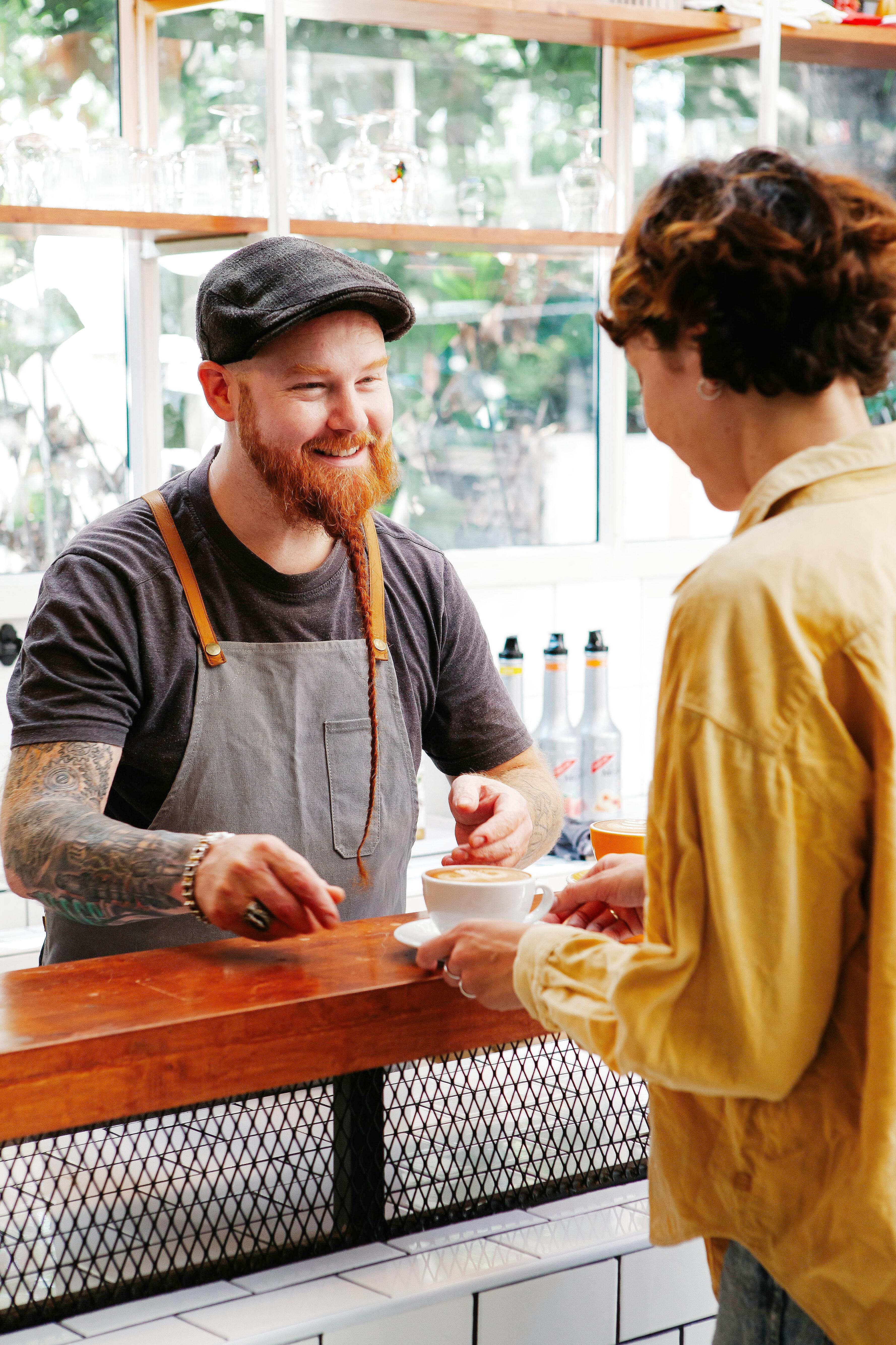 Person casually greeting barista in coffee shop micro interaction
