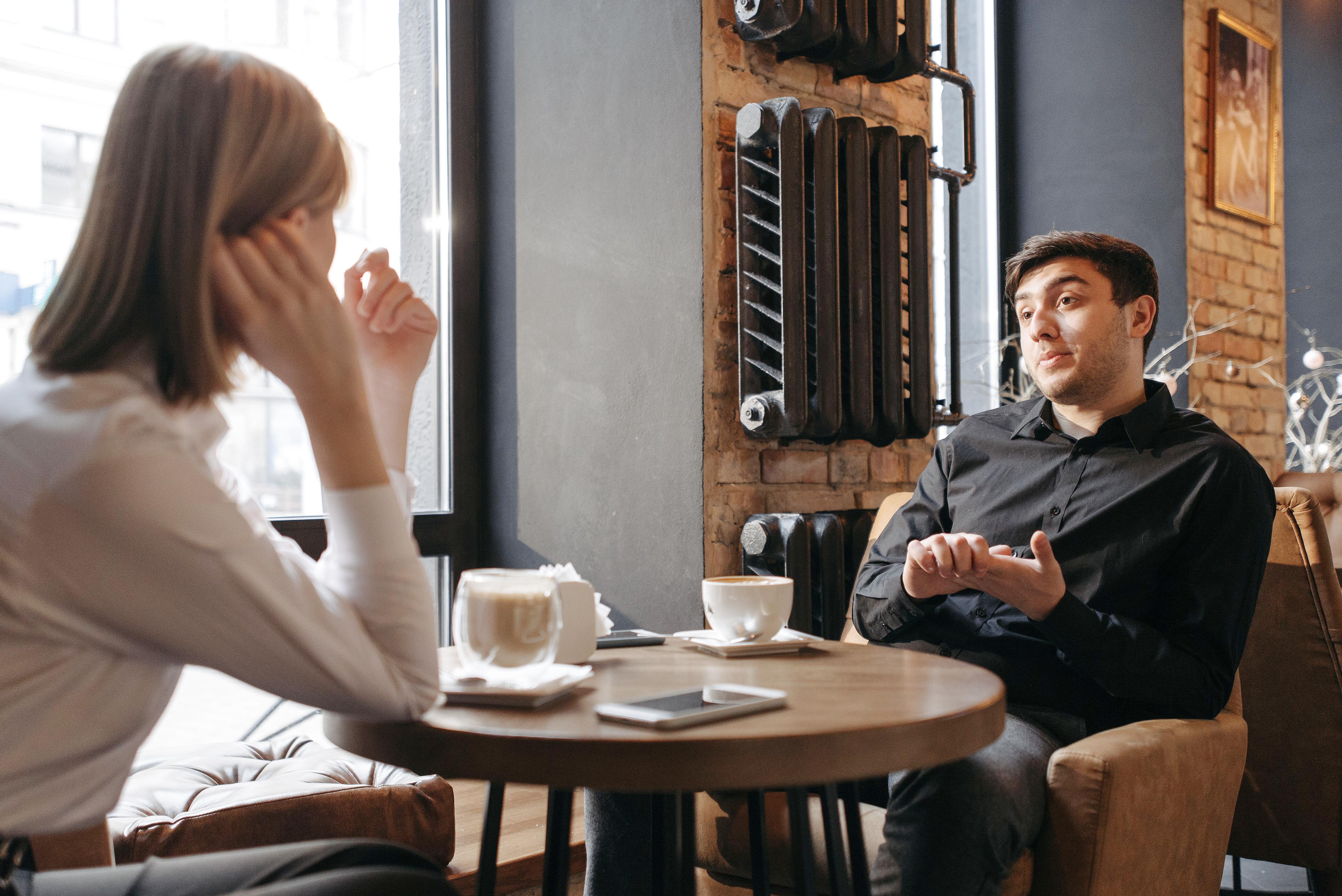 Couple discussing mental health and emotional intelligence over coffee
