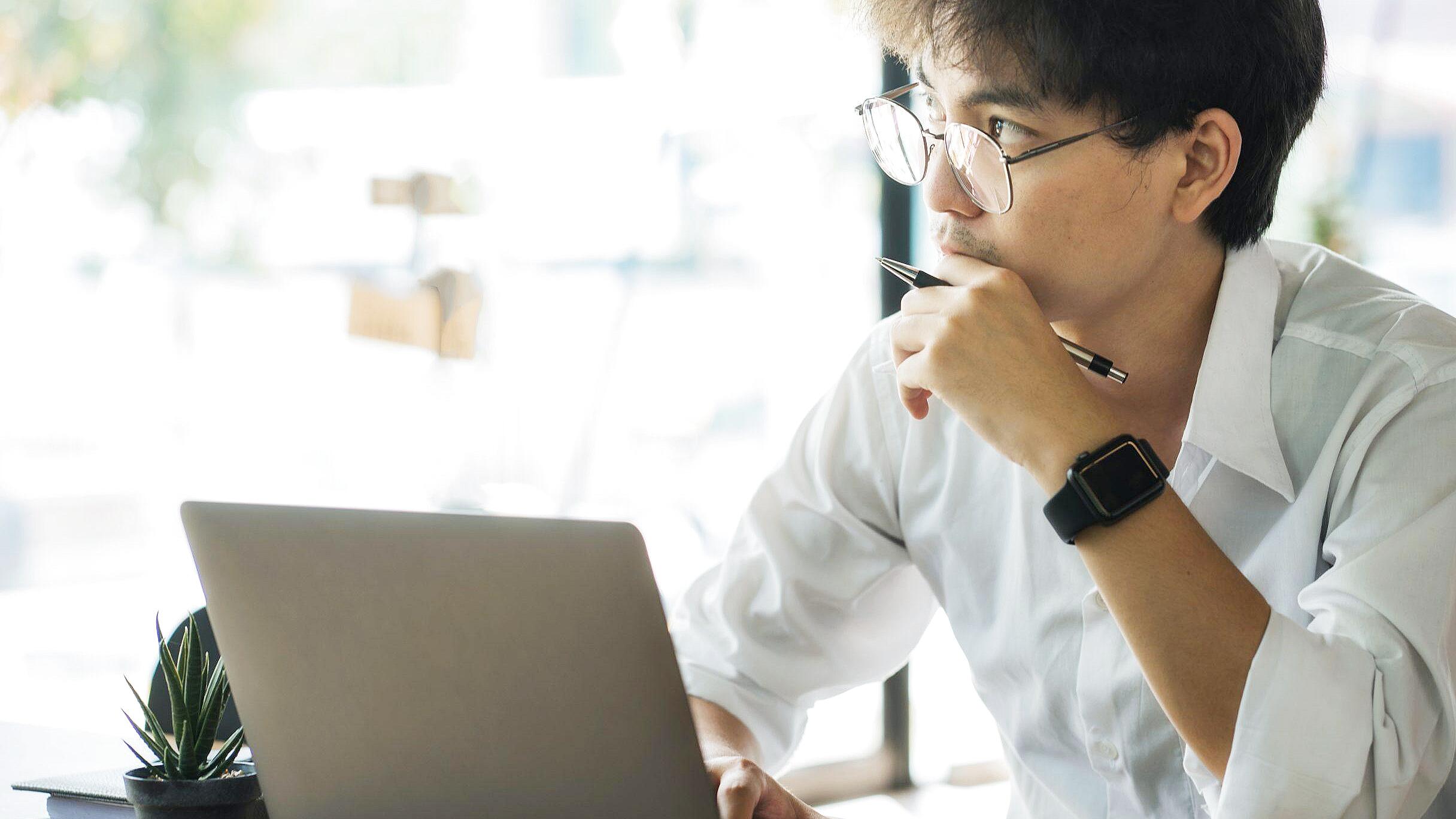 Man taking emotional intelligence self-assessment on laptop at home