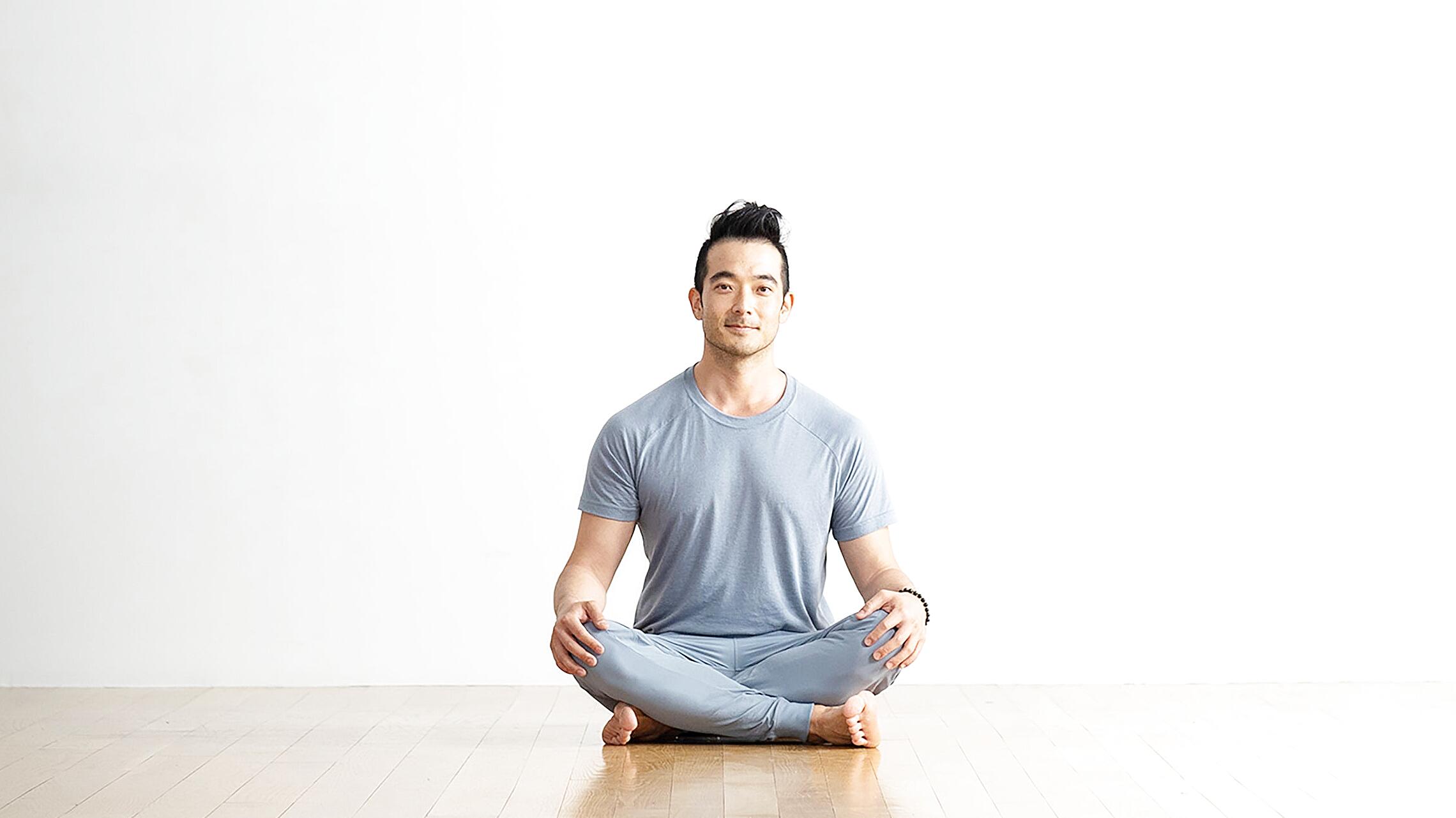 Person sitting with hands on knees practicing mindful breathing