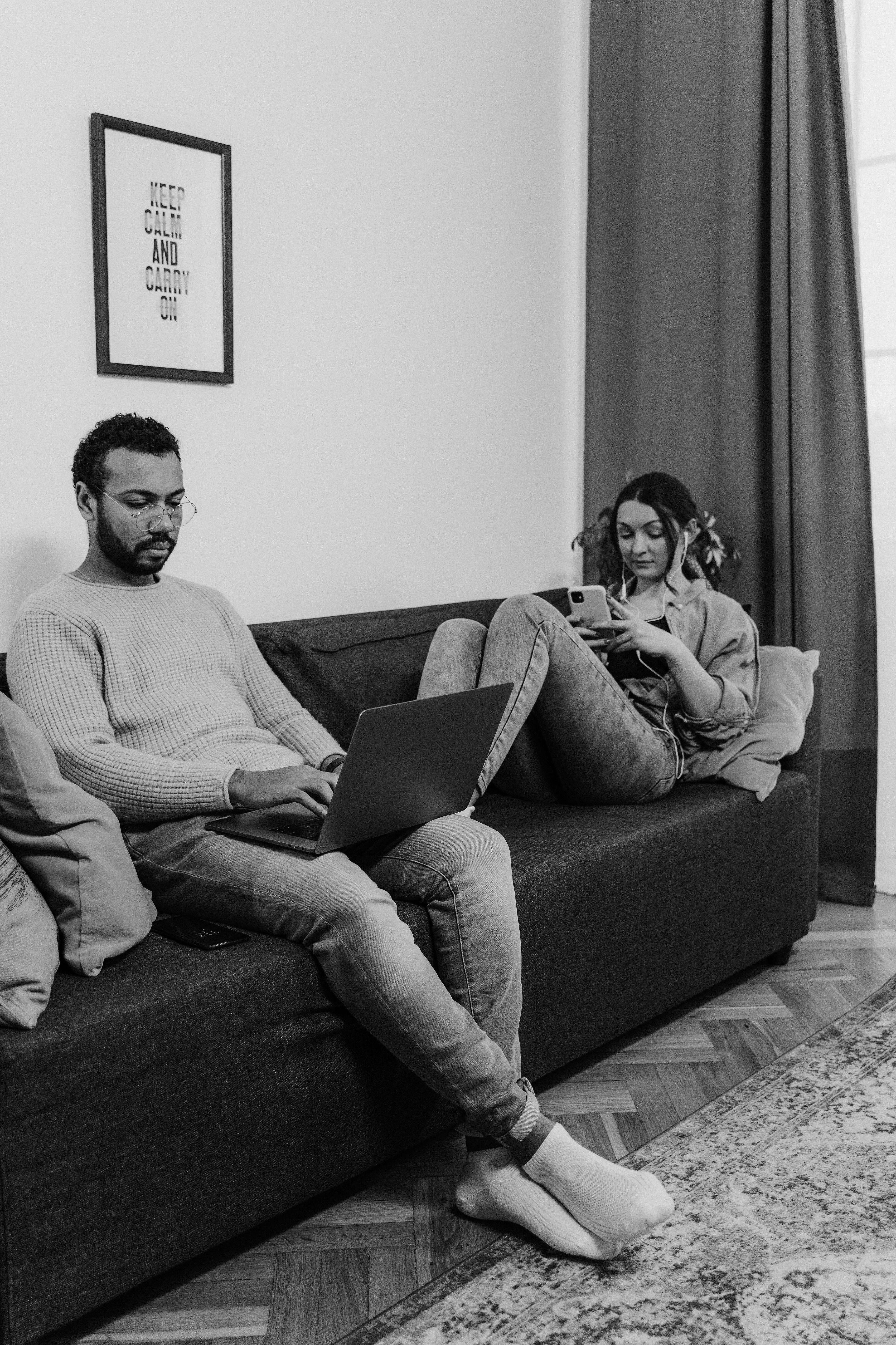 Couple sitting on couch holding hands with phones set aside for focused conversation