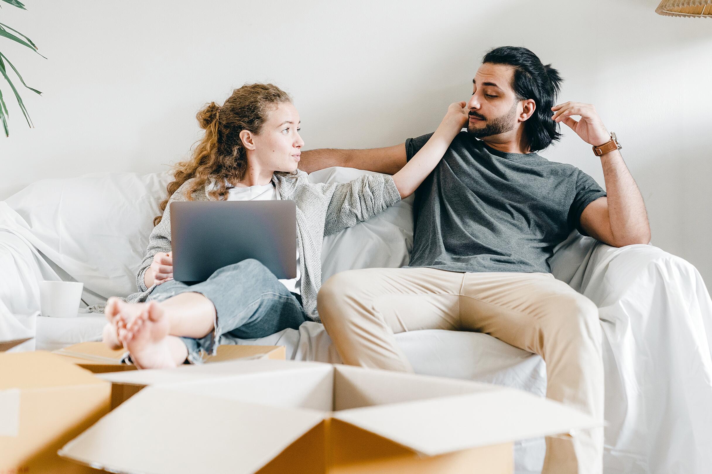 Couple participating in online couples therapy session on laptop at home
